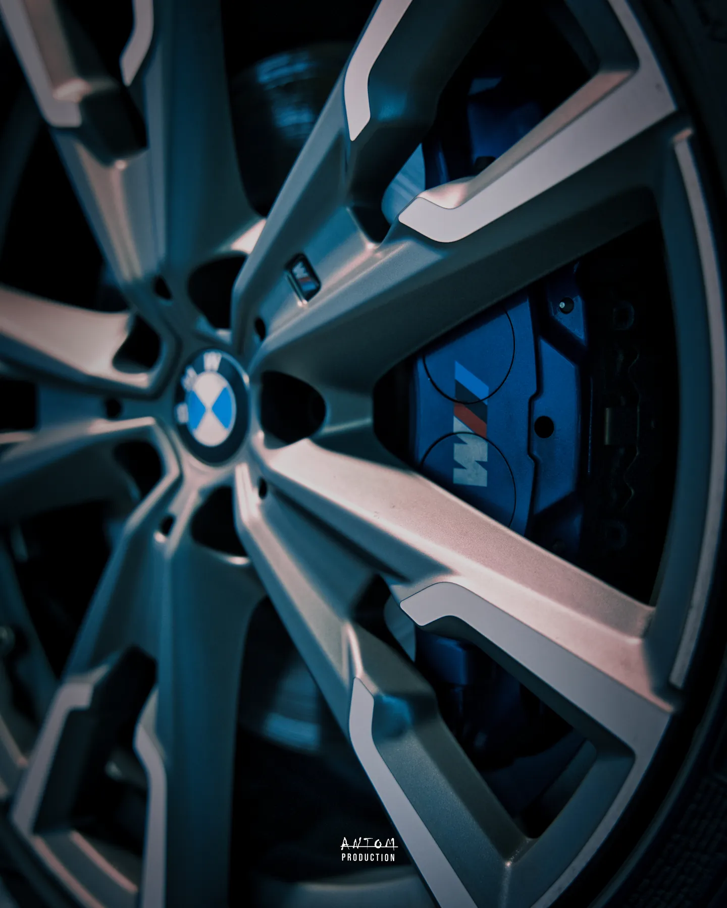 Gros plan sur une jante et un étrier de frein bleu, photographie de détail automobile