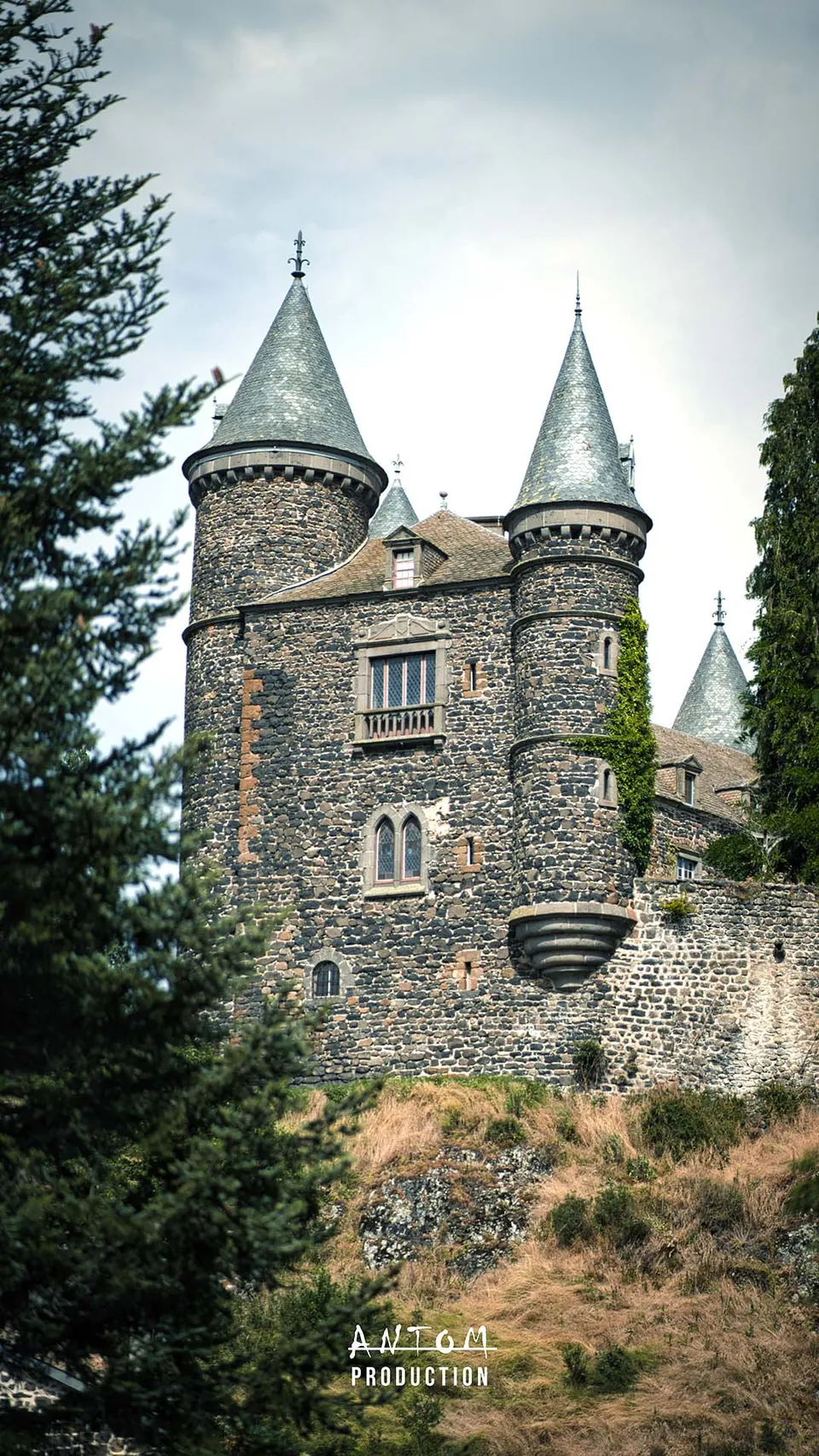 Tours coniques d'un château en pierre volcanique, vues en contre-plongée