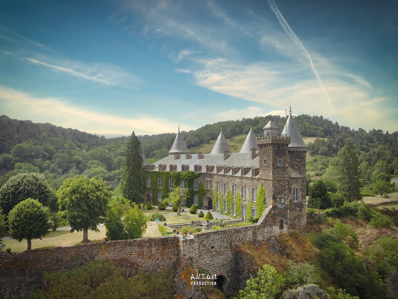 Château auvergnat et son parc sous un ciel d'été