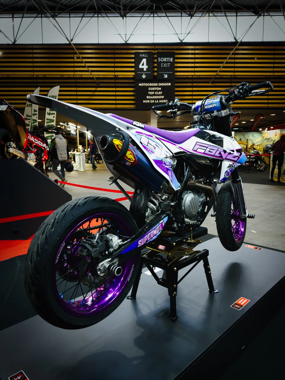 Supermotard aux jantes violettes sur un stand du Salon du 2 Roues
