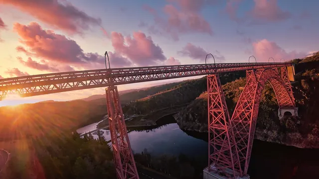 Soleil couchant derrière le tablier du viaduc de Garabit, vue par drone